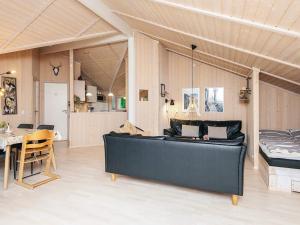 ein Wohnzimmer mit einer schwarzen Couch und einem Tisch in der Unterkunft 8 person holiday home in Ebeltoft-By Traum in Ebeltoft