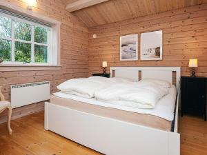 a bedroom with a white bed in a wooden room at 4 person holiday home in Egå in Egå