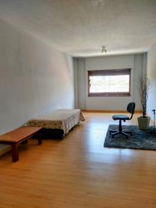 una camera da letto con un letto, una scrivania e una sedia di Apartamento amplo 2 quartos no centro ad Águas de Lindóia