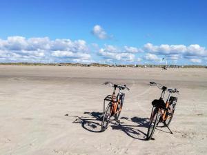 due biciclette parcheggiate nella sabbia su una spiaggia di 9 person holiday home in Rømø a Vesterhede Altre 46 foto