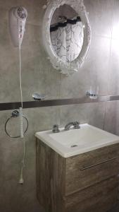 a bathroom with a sink and a mirror at La Cabaña de Lali in Monte Hermoso