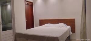 a white bed in a room with a mirror at Pousada horbis in Guarabira