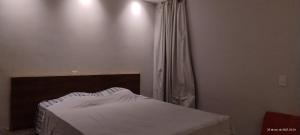 Schlafzimmer mit einem Bett mit weißer Bettwäsche und einem Fenster in der Unterkunft Pousada Horbis in Guarabira