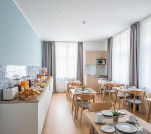 een restaurant met tafels en stoelen en een keuken bij Sevcan Apart 