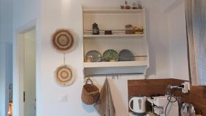 a kitchen with white shelves with items on it at Andros summer house in Kipri