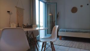 a living room with a table and chairs and a bed at Andros summer house in Kipri