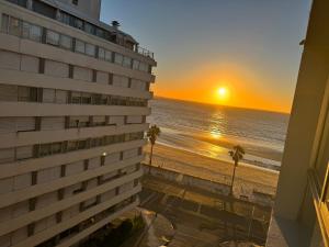 Apartamento en POCITOS vista al mar في مونتيفيديو: اطلالة على الشاطئ وقت الغروب من شرفة الفندق