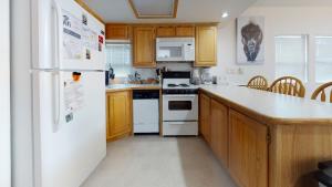 una cucina con elettrodomestici bianchi e armadietti in legno di #160 Tiger Run a Gold Hill