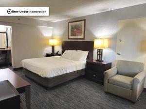 a hotel room with a bed and a chair at The Lodge Hotel and Banquets in Bridgeton +24 photos