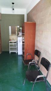 a room with chairs and a kitchen with a green floor at Monoambiente Para 2 in Belén