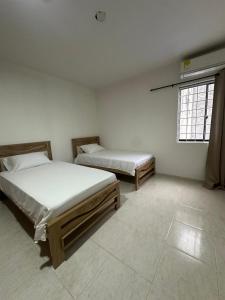 a bedroom with two beds and a window at Grande y Hermoso apartamento urbano in Montería +15 photos