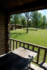 un banco de madera sentado en el porche de una cabaña en Fremont RV Campground Loft Cabin 4, en Fremont