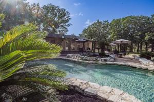a swimming pool in front of a house at Ranch | 4 Homes | Pool | Sleeps 40 in Luling