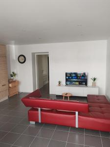 a red couch in a living room with a tv at Tini in Hayange