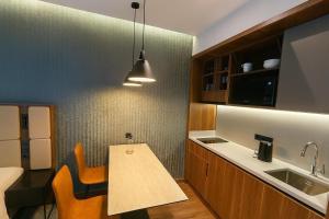 a kitchen with a sink and a table with chairs at Privilege Skyscraper Resort - Marriott Tower Sea View in Batumi