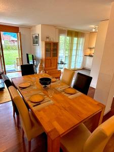 a wooden table with chairs and a dining room at Alpine Haven Base Chalet in Arni Alp