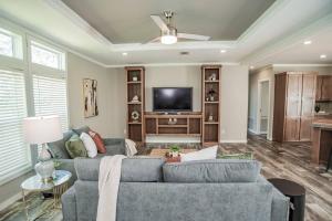 a living room with a couch and a flat screen tv at Ranch | 4 Homes | Pool | Sleeps 40 in Luling