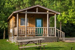 Cabaña de madera con un banco en el césped en Fremont RV Campground Cottage 28, en Fremont