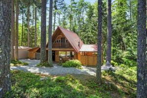 a log cabin in the woods with trees at Antler House in Ashford