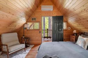 a bedroom with a bed and a chair in a cabin at Antler House in Ashford