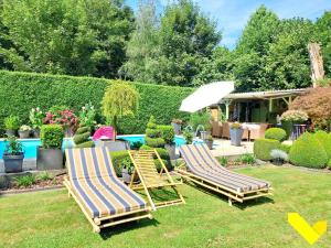 two lounge chairs and an umbrella in a yard at Wezelhoeve in Balen +9 photos