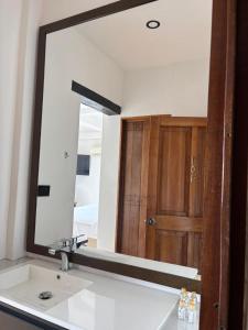 a bathroom mirror with a sink and a wooden door at Terraza De San Antonio in Cali +86 photos