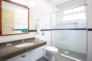 a bathroom with a toilet and a sink and a shower at Oscar Hotel in Florianópolis