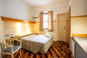 a bedroom with a bed and a chair in it at Oscar Hotel in Florianópolis +30 photos