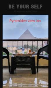 a table and chairs with a view of a pyramid view at Pyramiden view inn in Banī Ghālib