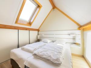 Un dormitorio con una cama con sábanas blancas y una ventana. en Westhinder II H53, en Witte Burg
