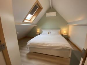 1 dormitorio con 1 cama blanca en el ático en Westhinder II H3, en Witte Burg