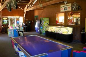a ping pong table in a room with arcade games at Fremont RV Campground Loft Cabin 1 in Fremont