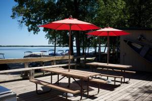 two picnic tables with red umbrellas on a dock at Fremont RV Campground Loft Cabin 1 in Fremont