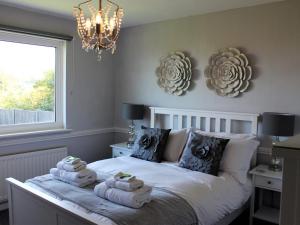 1 dormitorio con 1 cama con toallas y lámpara de araña en 3 bed in Gorran Haven 83495, en Gorran Haven