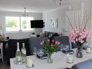 una sala de estar con una mesa con botellas de vino y flores en 3 bed in Gorran Haven 83495, en Gorran Haven
