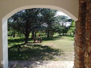 an archway with a person sitting in a park at El morenito in La Granja +11 photos