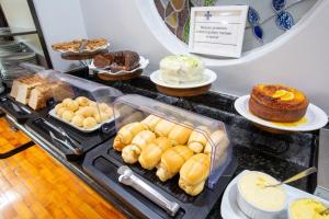 a counter with different types of pastries and cakes at Oscar Hotel in Florianópolis