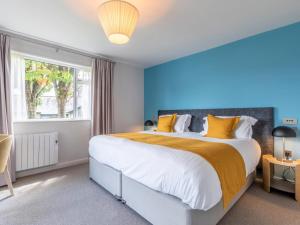 a bedroom with a large bed with yellow pillows at 2 Bed in St. Mellion 87710 in St Mellion +23 photos
