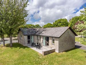 a small brick house with a patio in a yard at 2 Bed in St. Mellion 87710 in St Mellion