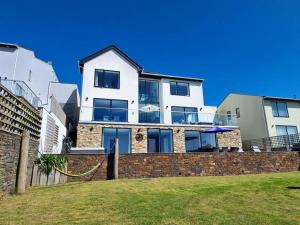 a large white house on top of a brick wall at 5 Bed in Polruan 77657 in Polruan