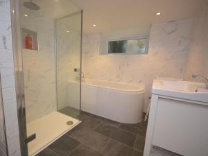 a bathroom with a shower and a tub and a sink at 3 Bed in Polruan PC012 in Polruan