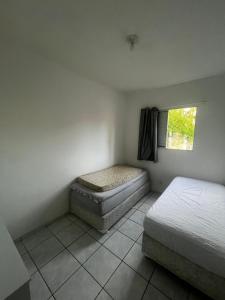 a small bedroom with a bed and a window at Apartmento Itanhaem in Itanhaém