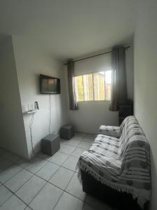 a bedroom with a bed and a window at Apartmento Itanhaem in Itanhaém