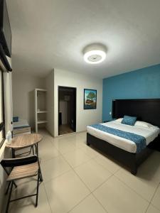 ein Schlafzimmer mit einem Bett, einem Tisch und einem Stuhl in der Unterkunft Hotel Santa Teresa in Tequila + 8 Fotos