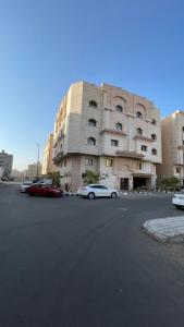 a building with cars parked in a parking lot at A very classy and private apartment in Al Madinah