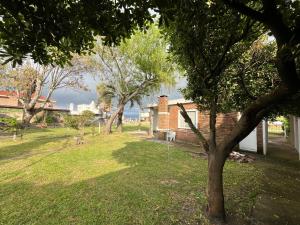 a yard with trees and a brick building at Corbeta in Piriápolis