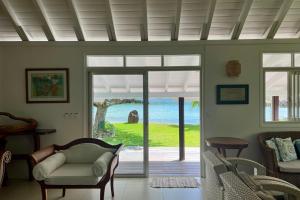 a living room with a view of the ocean at Villa Ohana - 4BR Beachfront Villa in Paopao