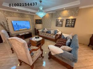 un soggiorno con divani e TV a schermo piatto di شقه عائليه 401سوبر لوكس في وسط الحي الافرنجي في مركز المدينه a Port Said