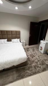 a bedroom with a large white bed and a door at Apartment, room, elegant and comfortable hall, and smart entrance in Al Madinah +5 photos