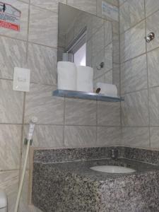 a bathroom with a sink and a mirror and towels at Flat do Golfinho in Tamandaré